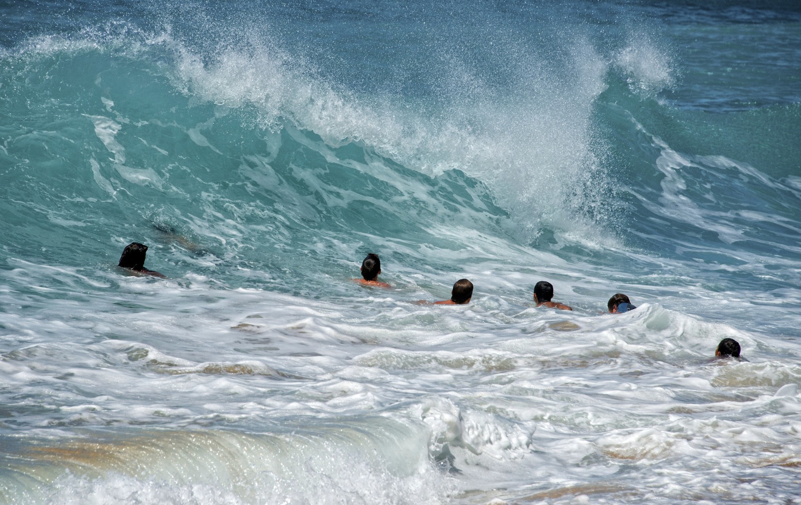 Teens swimming in waves 1